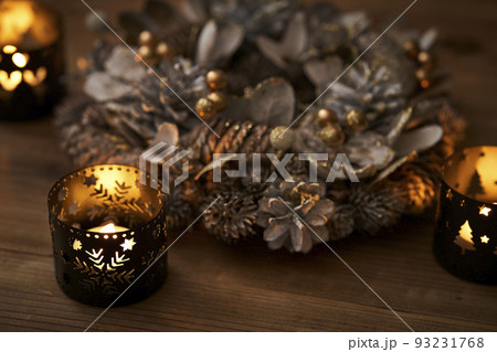 キャンドルに照らされたクリスマスリース　クリスマスイメージ 93231768