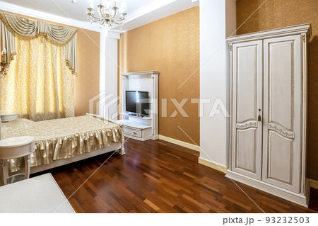 Bedroom with a large bed and a TV in front of it Bedroom with a large bed and a TV in front of it 93232503