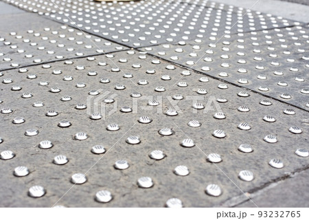 Tactile tiles for the blind. Panels for the blind laid on asphalt. Guide tape for the disabled. the inscription look right at the pedestrian crossing. Modern metal signs for the blind. 93232765