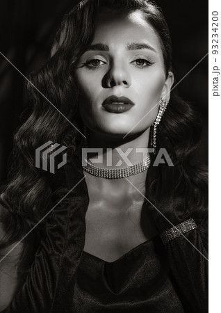 Portrait of an elegant woman in vintage retro style of black and white Hollywood movies with makeup and hairstyle. Portrait of an elegant woman in vintage retro style of black and white Hollywood movies with makeup and hairstyle. 93234200