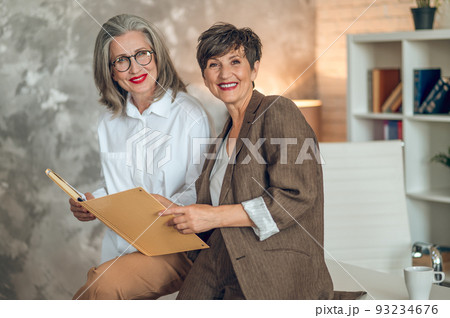 Mid aged good-looking women working together in the office Mid aged good-looking women working together in the office 93234676