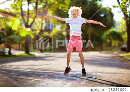 Kids play hopscotch in summer park. Outdoor game. 93235002