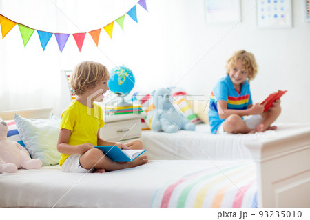 Child reading in bed. Kids read. Boy at home. 93235010