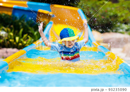 Kids on water slide in aqua park. Summer vacation Kids on water slide in aqua park. Summer vacation 93235090