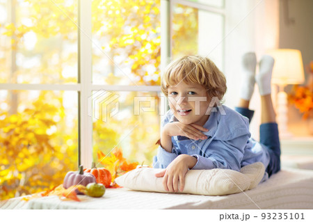 Child at window in autumn. Kids at home in fall. Child at window in autumn. Kids at home in fall. 93235101