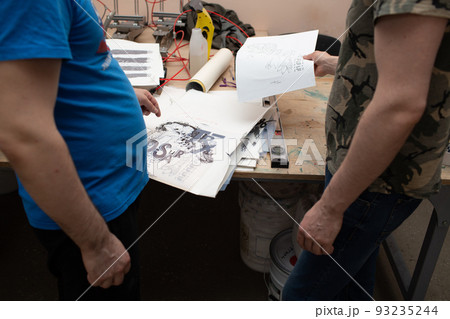 Serigraphy silk screen print process at clothes factory. Pattern stencil template frame. Serigraphy silk screen print process at clothes factory. Pattern stencil template frame. 93235244