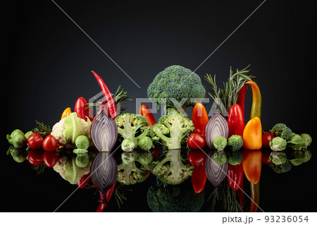 Various raw vegetables on a black reflective background. 93236054