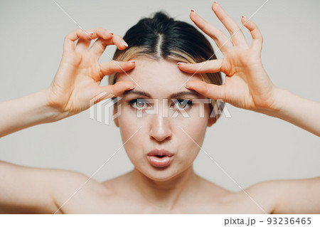Young adult doing facial gymnastics self massage and rejuvenating exercises face building and lifting Young adult doing facial gymnastics self massage and rejuvenating exercises face building and lifting 93236465