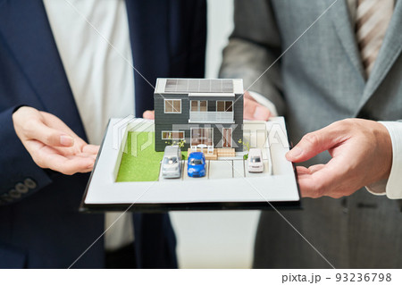 精巧な住宅模型を持つスーツ姿の男女 精巧な住宅模型を持つスーツ姿の男女 93236798