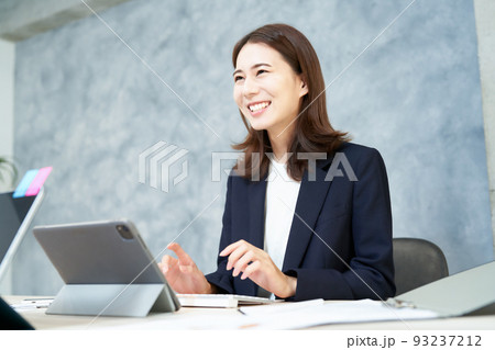 笑顔でデスクワークをするビジネスウーマン 93237212