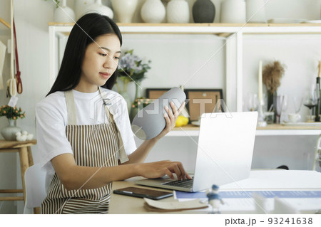 Young asian businesswoman fashion blogger showing ceramic products with smiling face. 93241638