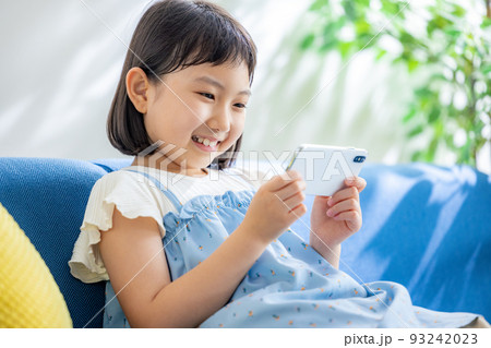 小学生の女の子がスマホをさわる 93242023