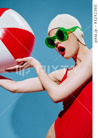 Shocked, excited swimmer with red ball for swimming looks away with her mouth open. Conceptual art of the new generation 93242360
