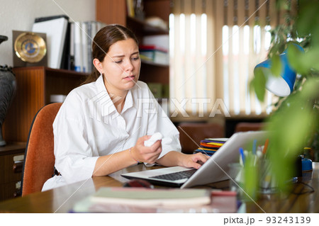 Frustrated girl in the office works at the computer 93243139