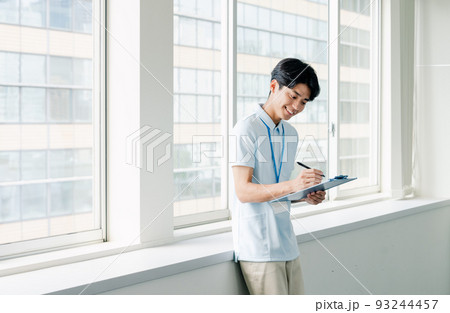 メモをする介護職員の男性 93244457