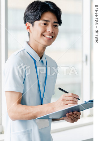 メモをする介護職員の男性 93244458