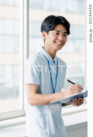 メモをする介護職員の男性 93244459