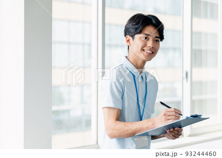 メモをする介護職員の男性 93244460
