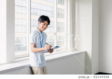 メモをする介護職員の男性 93244509