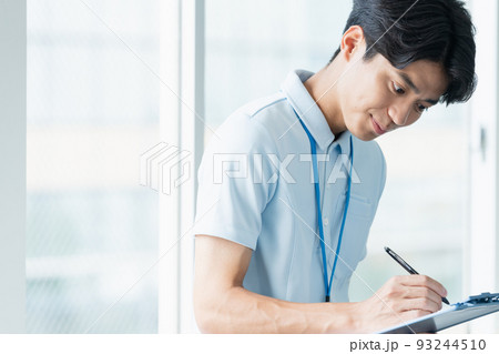 メモをする介護職員の男性 メモをする介護職員の男性 93244510