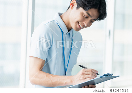 メモをする介護職員の男性 メモをする介護職員の男性 93244512
