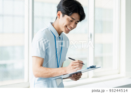 メモをする介護職員の男性 93244514