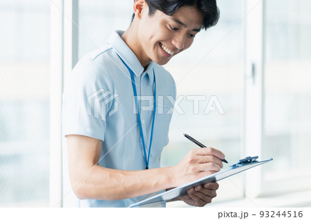 メモをする介護職員の男性 メモをする介護職員の男性 93244516