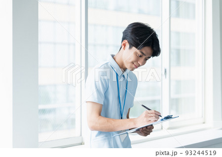 メモをする介護職員の男性 メモをする介護職員の男性 93244519