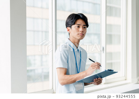 メモをする介護職員の男性 93244555