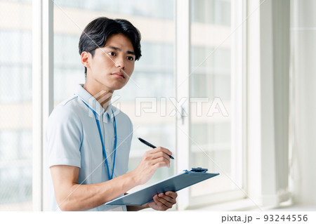 メモをする介護職員の男性 93244556