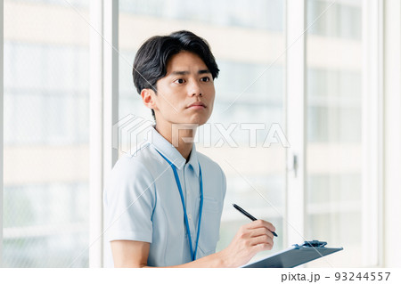メモをする介護職員の男性 93244557