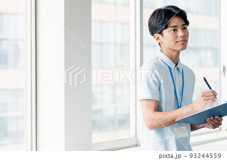 メモをする介護職員の男性 93244559