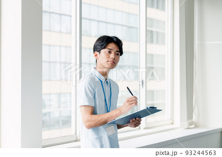 メモをする介護職員の男性 93244563