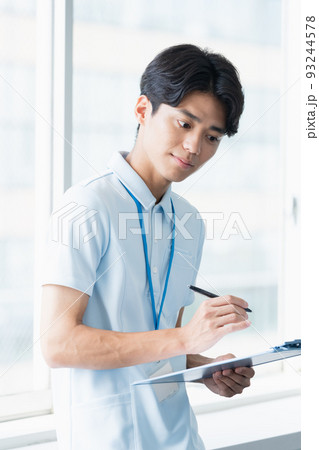 メモをする介護職員の男性 93244578