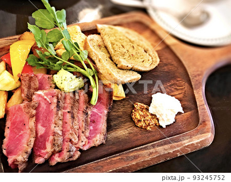 食欲をそそるウッドプレートの肉料理 93245752