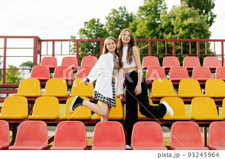 Teenage girls relax together in the school stands. The concept of friendship and relationships 93245964