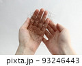 長い抜け毛を持つ女性の手 93246443