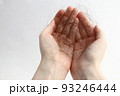 長い抜け毛を持つ女性の手 93246444