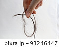 長い抜け毛を持つ女性の手 93246447