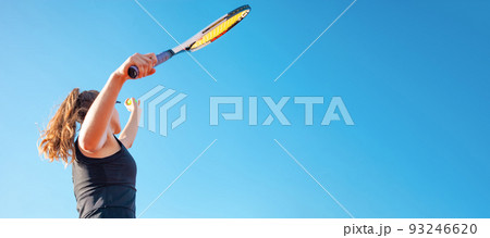 A beautiful young woman serves the ball. Tennis court, sunlight. The girl in the black suit dress. A sporty lifestyle in the open air. A professional athlete trains. banner A beautiful young woman serves the ball. Tennis court, sunlight. The girl in the black suit dress. A sporty lifestyle in the open air. A professional athlete trains. banner 93246620
