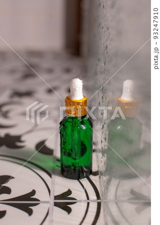 SPA natural organic cosmetics for personal hygiene. Green glass pump cosmetic bottle on ceramic board in bathroom. Hydration, moisturizing products for daily woman's routine 93247910