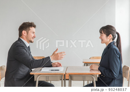 学校で二者面談を行う教師とアジア人の高校生 93248037