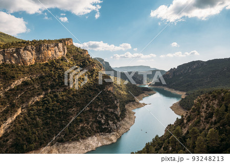 Beautiful landscape of forest woods and calm tranquil lake. Fat white clouds on blue sky in aerial drone shot. 93248213