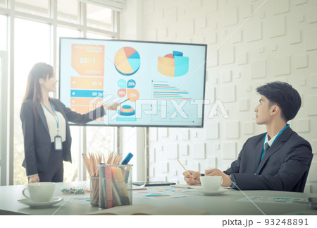 Confidence usiness woman is presenting Data on a Monitor in a meeting room for team mate. Confidence usiness woman is presenting Data on a Monitor in a meeting room for team mate. 93248891