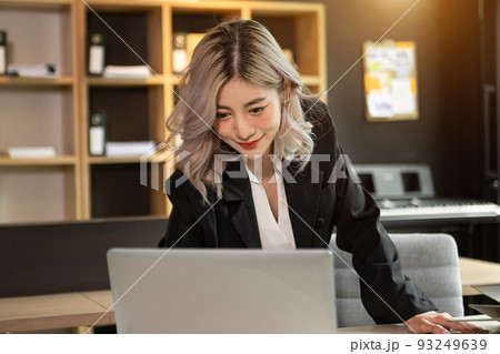 Beautiful Asian business woman typing laptop and tablet Placed at the table at the office Beautiful Asian business woman typing laptop and tablet Placed at the table at the office 93249639