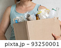Female holding box of recycling materials, white background 93250001