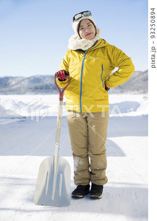 きれいに雪かきをして満足する若い女性 93250894