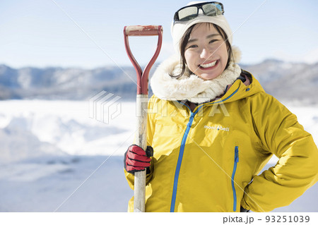 きれいに雪かきをして満足する若い女性 93251039