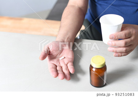 薬を飲むシニア男性の手元 93251083