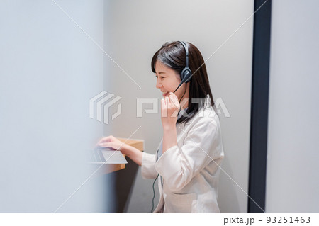 シェアオフィスの個室ブースでリモート会議をする女性 93251463